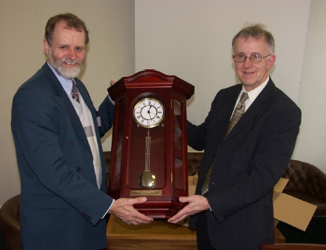 P&Q's M.D. Donald Gardiner presenting a radio-controlled pendulum clock to Dunlop Oil & Marine's H.R. Manager John Young